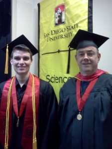 Thomas Schmidt and Alan Riggins caps and robes for the graduation ceremony